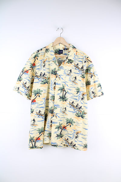 Gap Hawaiian Surfer Shirt in a yellow colourway, surfer and floral design printed all over, button up with a camp collar and has a chest pocket.