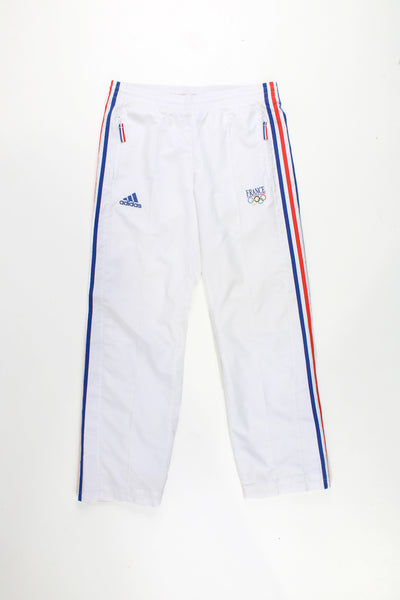 Adidas Tracksuit Bottoms in a white colourway with the iconic 3 strips in blue and red going down the sides, has a elasticated waist, pockets, and logos embroidered on the front.