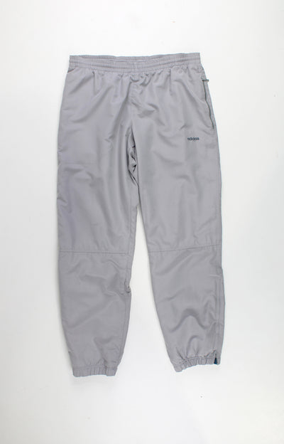 Adidas Tracksuit Bottoms in a plain grey colourway, has a elasticated waist, pockets, and logo embroidered on the front and back.