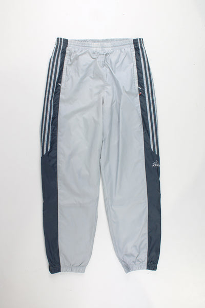 Adidas Tracksuit Bottoms in a grey colourway with the iconic 3 stripes going down the legs, has a elasticated waist, pockets, and logo embroidered on the left leg.