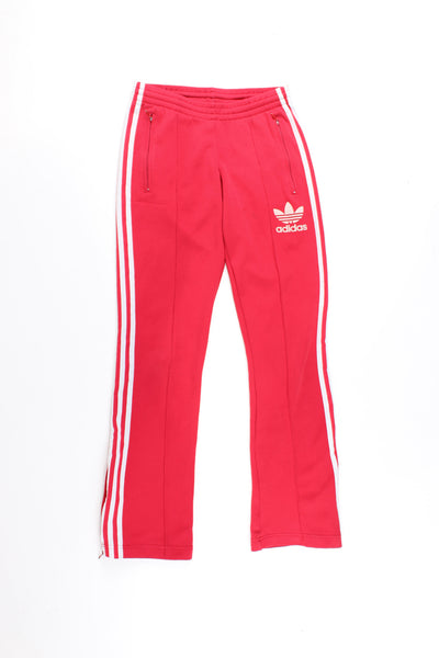 Adidas Tracksuit Bottoms in a red colourway with the iconic 3 white stripes going down the legs, has a elasticated waist, pintucked, pockets, and logo embroidered on the front.