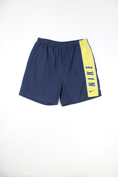 Nike Shorts in a blue and yellow colourway, adjustable waist, pockets, netted lining, and has the logo and spell out printed down the left side.