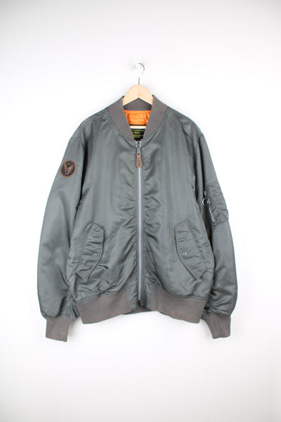 Vintage Alpha Industries bomber jacket in grey. Features leather patch on the sleeve and closes with a full zip.  Good Condition - some light marks and scratches (see photos)  Size in Label:   Mens XL