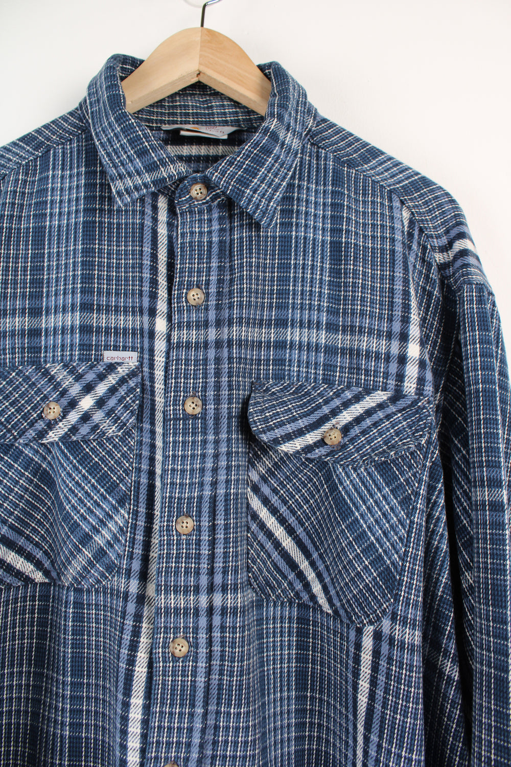 Navy blue plaid Carhartt button up shirt, has small embroidered logo on chest pocket