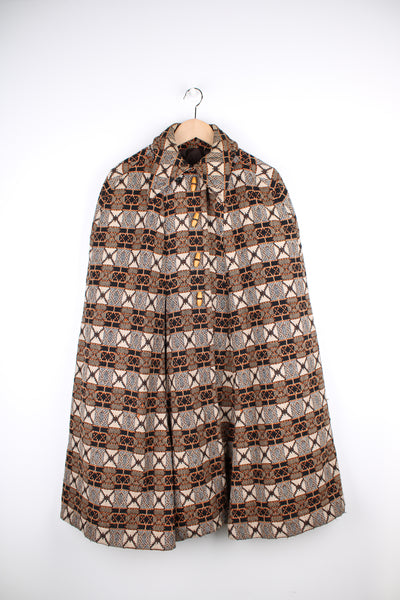 True vintage 1960's tapestry cape with dagger collar and wooden buttons to close. Geometric print in cream, tan and orange.  good condition  Size in Label:   No Size - Would estimate that it  would fit a Womens M best.   Our Measurements:  Shoulder: 20 inches  Width (from the widest point): 42 inches Length: 39 inches