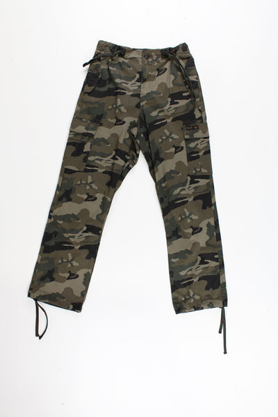 Bench Camo Cargo Trousers in a green, black and brown colourway, multiple utility style pockets, adjustable waist and cuffs, and has the logo embroidered on the front pocket.