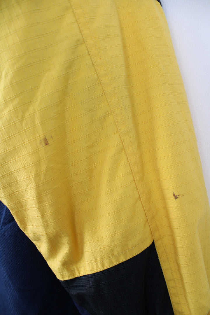 Columbia Tectonite Jacket in a yellow and navy blue colourway, zip up, multiple pockets, insulated lining, hooded and has the logo embroidered on the front.