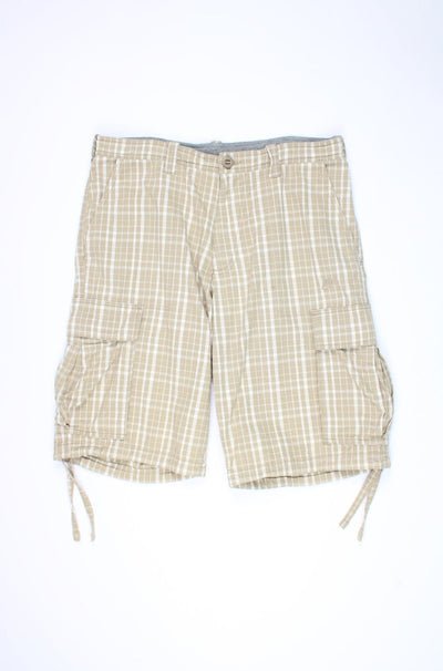 Nike tan checkered cargo shorts with multiple pockets and embroidered logo near the hem