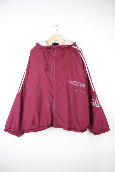 Vintage Adidas maroon red shell jacket with embroidered logo on the chest, embroidered three stripes down the arms and zip up pockets