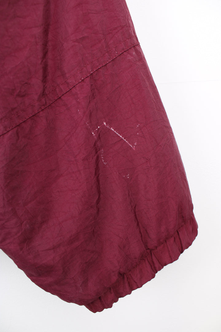 Vintage Adidas maroon red shell jacket with embroidered logo on the chest, embroidered three stripes down the arms and zip up pockets