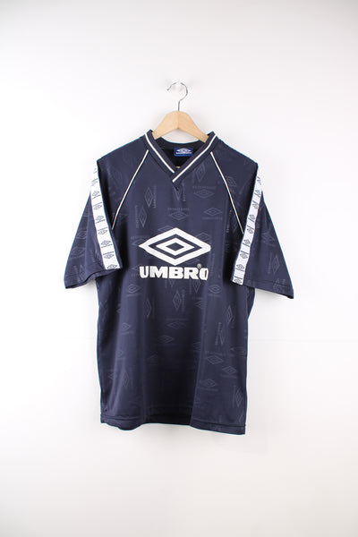 Vintage navy blue 90's Umbro football training t-shirt. V-neck with branded Umbro ribbon going down the sleeves. Also features printed white Umbro logo in the center. good condition  Size in Label: Mens L