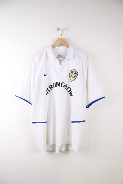 Leeds United 2002 - 2003 home football shirt made by Nike. Features embroidered logos on the chest and flocked "Strongbow" sponsorship across the chest.