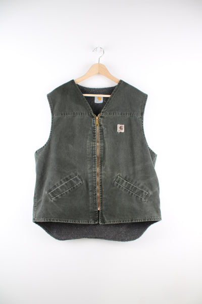 Carhartt Gilet in a green colourway, v neck, zip up with side pockets, sherpa lining and has the logo embroidered on the front.