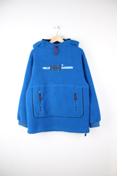 Helly Hansen Pullover Hoodie Fleece in a blue colourway, adjustable hood, big pouch pocket, and has embroidered spell out logo across the front.