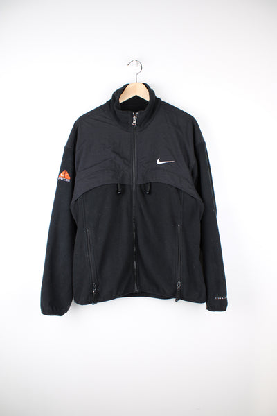 Nike ACG Fleece in a black colourway, zip up, multiple pockets and has the logo embroidered on the front and right sleeve.