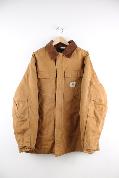 Carhartt Arctic Jacket in a tanned colourway with a brown corduroy collar, zip up, multiple pockets, and has the logo embroidered on the front.