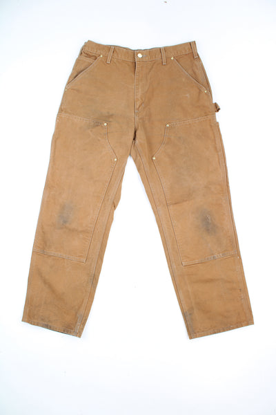 Carhartt double knee carpenter jeans in tan with multiple pockets and signature logo on the back pocket