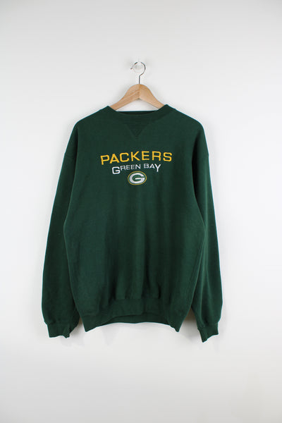Vintage 90's Green Bay Packers, green crew neck sweatshirt by Cadre Athletic. features embroidered spell-out motif on the front