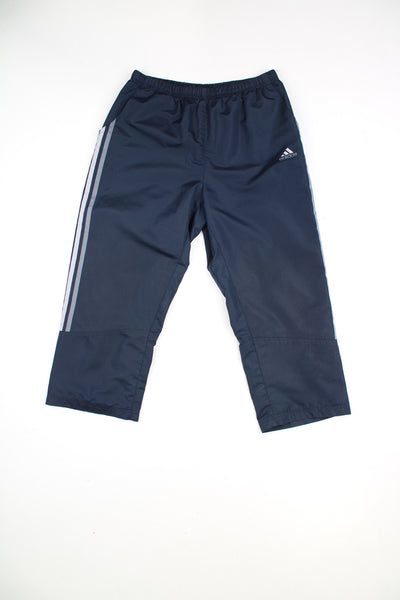 Adidas Tracksuit Bottoms in a navy blue colourway with grey three stripes going down the sides, adjustable waist, side pockets, and has the logo embroidered on the front.