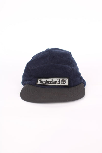 Timberland navy blue fleece baseball cap, made in the USA features embroidered spell-out logo on the front and foldaway ears