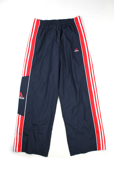 Vintage 00's Adidas black button up tracksuit bottoms with red and white stipes going down the side of both legs, embroidered logos and elasticated waist.