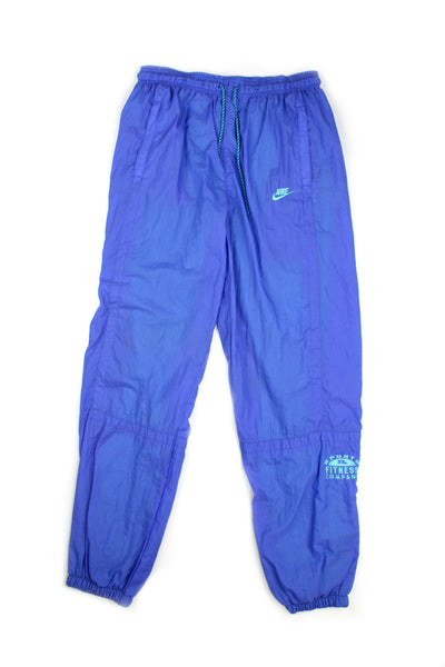 Vintage 90's Nike blue tracksuit bottoms with embroidered logo, has a elasticated waist and cuffed at the bottom. 
