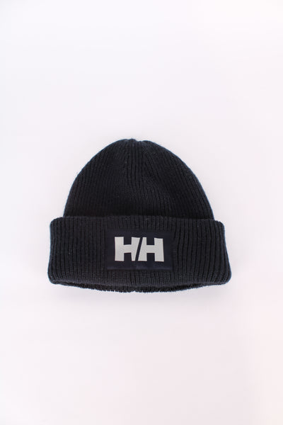 Navy blue Helly Hansen beanie hat with silver embroidered logo on the front