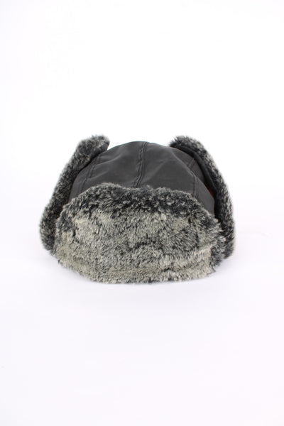 Black Adidas trapper hat with removable velcro badge logo on the side and faux fur lining. 