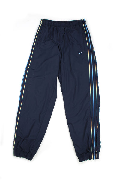 Vintage 00's Nike blue tracksuit bottoms blue and grey stripes down the side, embroidered swoosh logo, has a elasticated waist and cuffed at the bottom.
