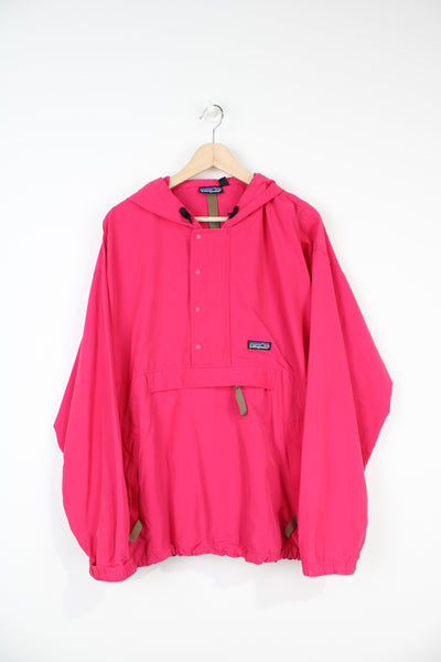 Patagonia pink windbreaker jacket with 1/4 zip and pockets, foldaways into a larger pocket