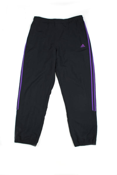 Vintage 00's Adidas black tracksuit bottoms with purple stripes down the side, embroidered logo, has a elasticated waist and cuffed at the bottom.