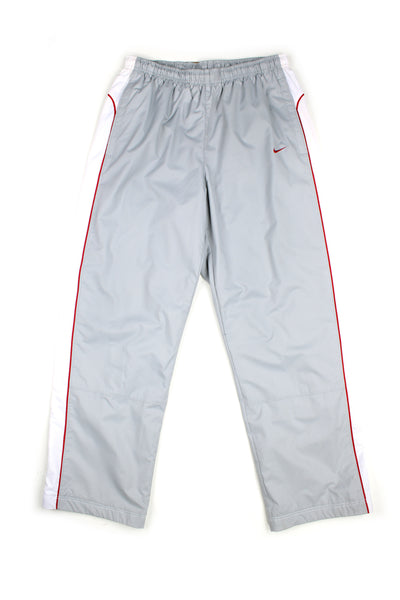 Vintage 00's Nike grey tracksuit bottoms with red and white stripes down the sides, embroidered swoosh logo and also has a elasticated waist.