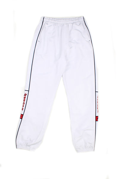Vintage 00's Reebok white tracksuit bottoms with black stripes down the sides, red embroidered logo, has a elasticated waist and cuffed at the bottom.