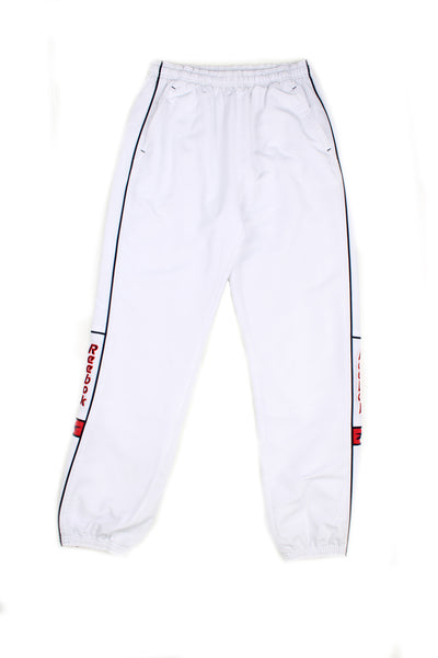 Vintage 00's Reebok white tracksuit bottoms with black stripes down the sides, red embroidered logo, has a elasticated waist and cuffed at the bottom.