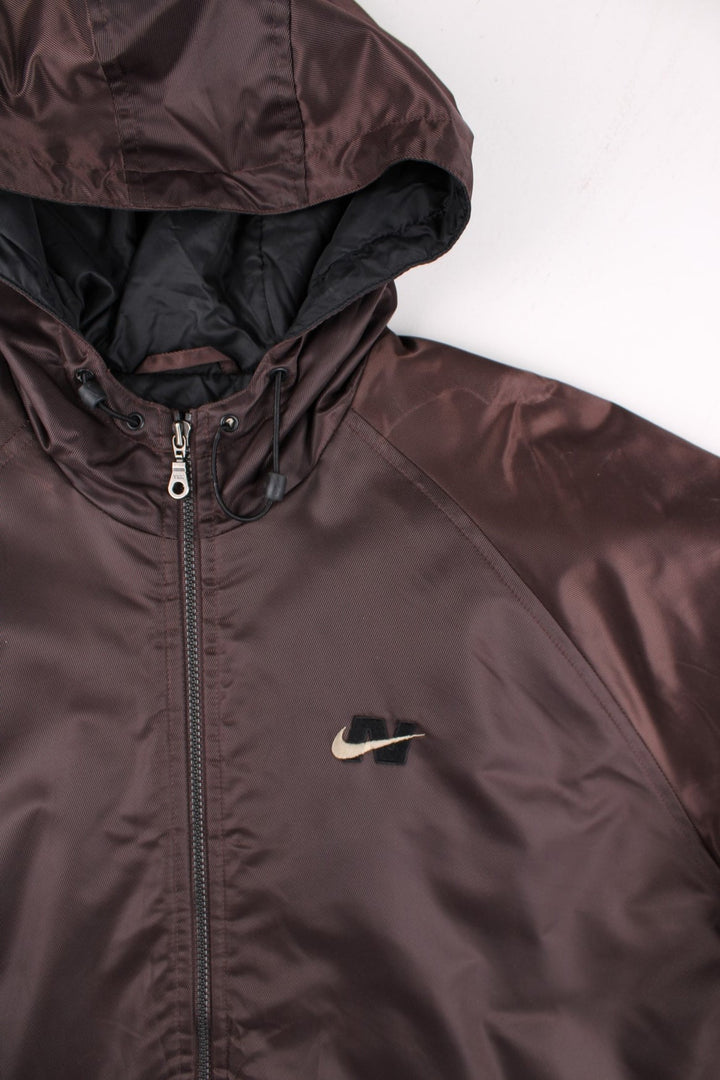 Vintage 90's Nike Parka Coat in a brown colourway. Zips up and has side pockets, insulated with a quilted lining, hooded, and has the swoosh logo embroidered on the front and back.