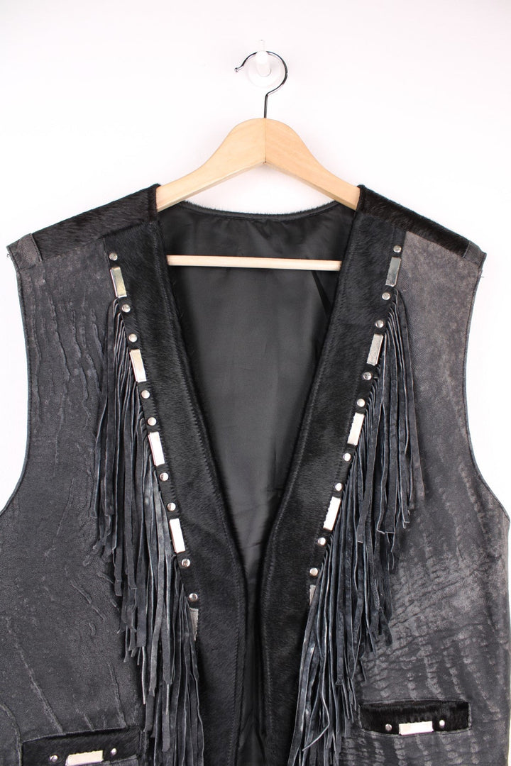 Vintage Leather Gilet in a black colourway with fringing, silver studs/cabochons and an animal hide trim. The gilet has some intentional wear to the leather, as seen in photos.  