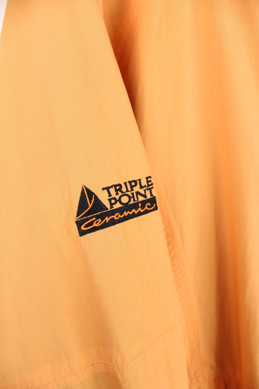 Vintage Lowe Alpine waterproof jacket in yellow with zip and snap closure, two front snapped pockets, an inside pocket, and a retractable hood. 