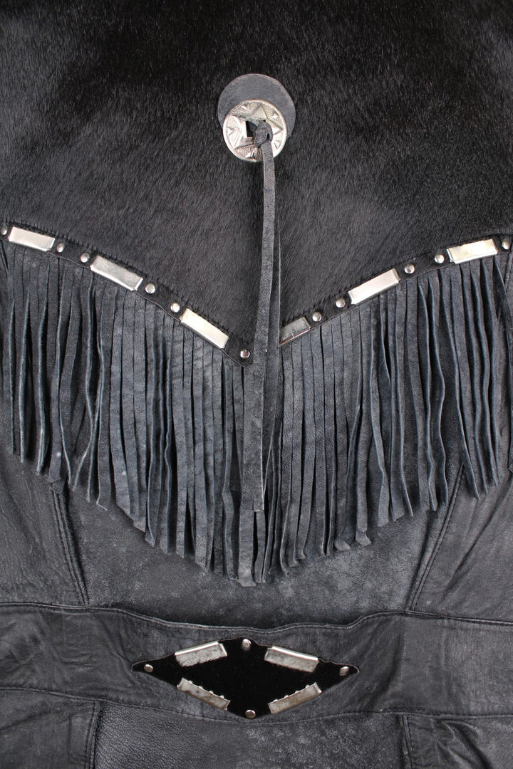 Vintage Leather Gilet in a black colourway with fringing, silver studs/cabochons and an animal hide trim. The gilet has some intentional wear to the leather, as seen in photos.  