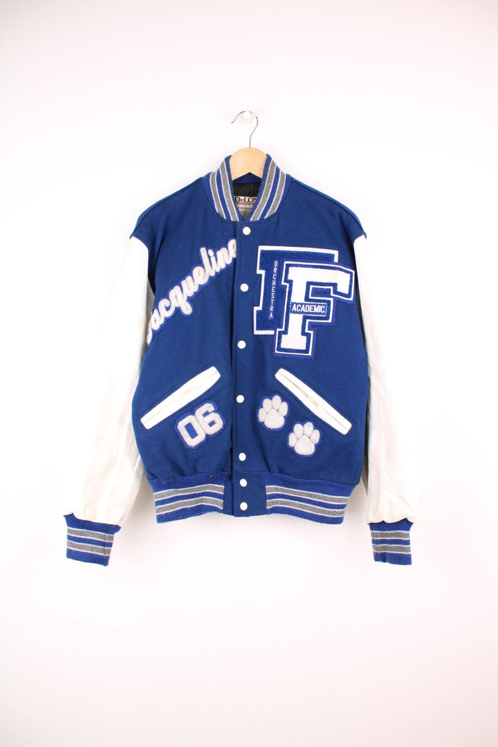 Vintage Delong, Fruita Monument Wildcats varsity jacket in blue with white leather sleeves. Features embroidered letterman patches and large spell out embroidery across the back.  