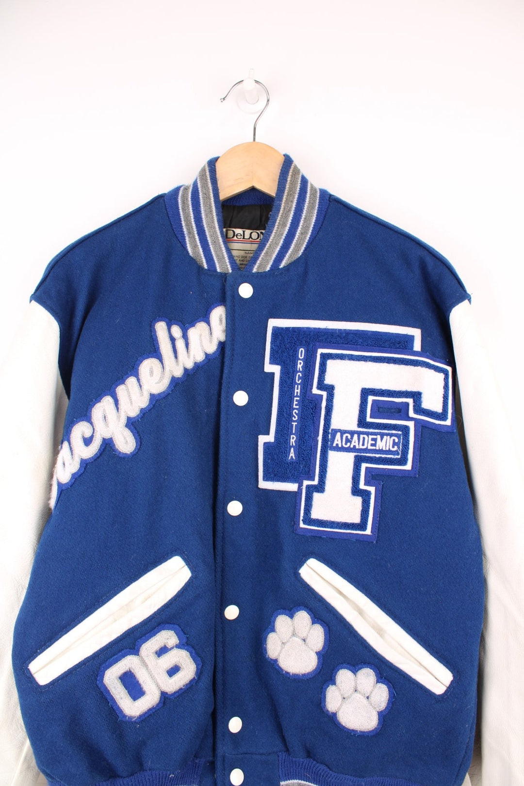 Vintage Delong, Fruita Monument Wildcats varsity jacket in blue with white leather sleeves. Features embroidered letterman patches and large spell out embroidery across the back.  