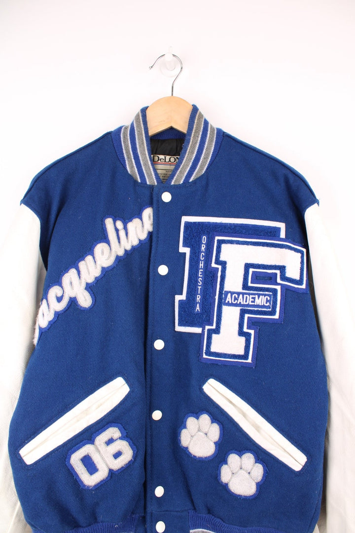 Vintage Delong, Fruita Monument Wildcats varsity jacket in blue with white leather sleeves. Features embroidered letterman patches and large spell out embroidery across the back.  