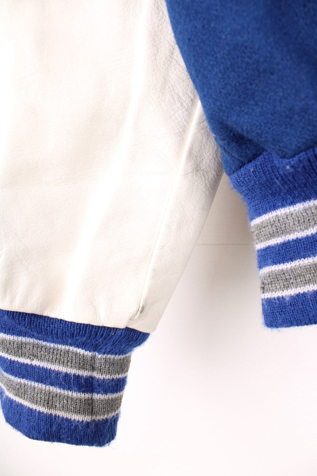 Vintage Delong, Fruita Monument Wildcats varsity jacket in blue with white leather sleeves. Features embroidered letterman patches and large spell out embroidery across the back.  