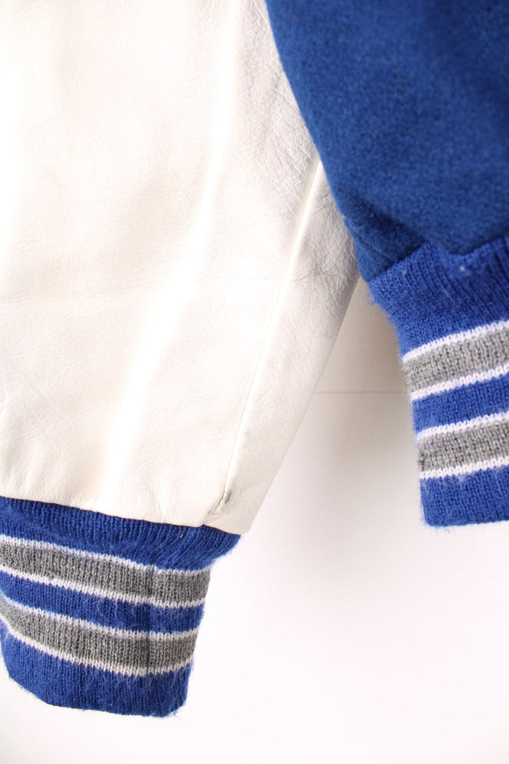 Vintage Delong, Fruita Monument Wildcats varsity jacket in blue with white leather sleeves. Features embroidered letterman patches and large spell out embroidery across the back.  