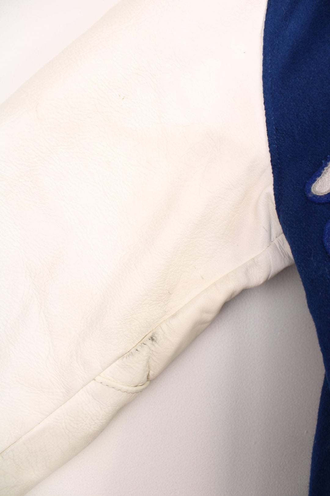 Vintage Delong, Fruita Monument Wildcats varsity jacket in blue with white leather sleeves. Features embroidered letterman patches and large spell out embroidery across the back.  
