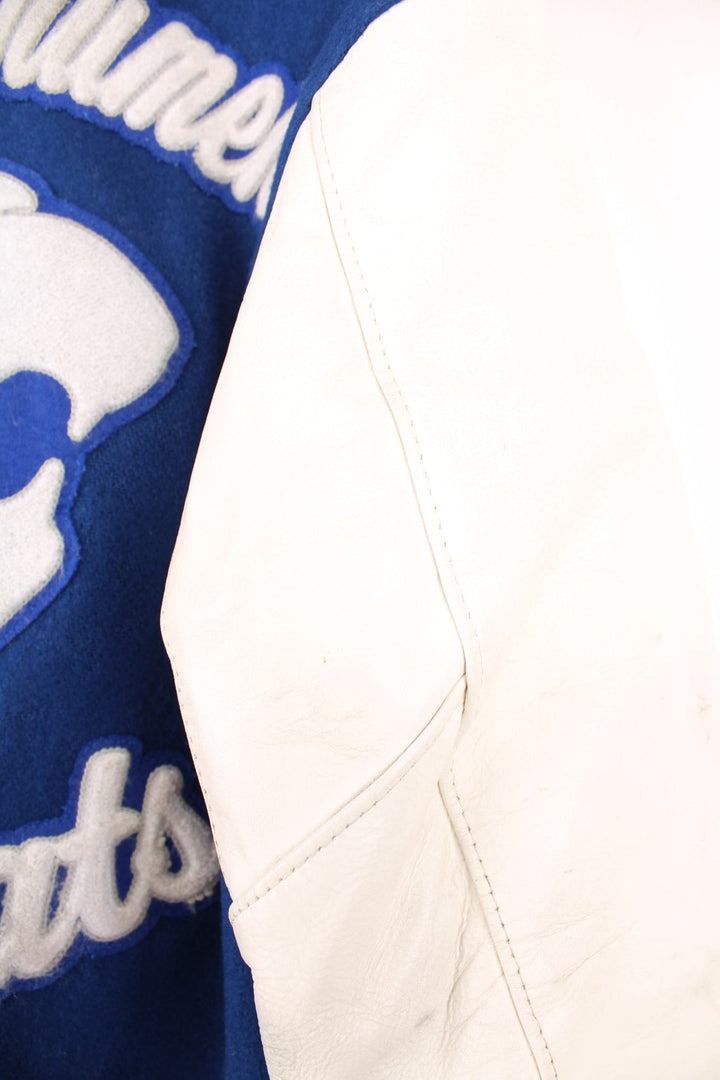 Vintage Delong, Fruita Monument Wildcats varsity jacket in blue with white leather sleeves. Features embroidered letterman patches and large spell out embroidery across the back.  