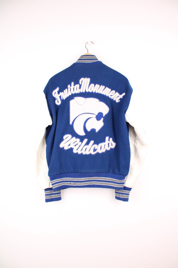 Vintage Delong, Fruita Monument Wildcats varsity jacket in blue with white leather sleeves. Features embroidered letterman patches and large spell out embroidery across the back.  