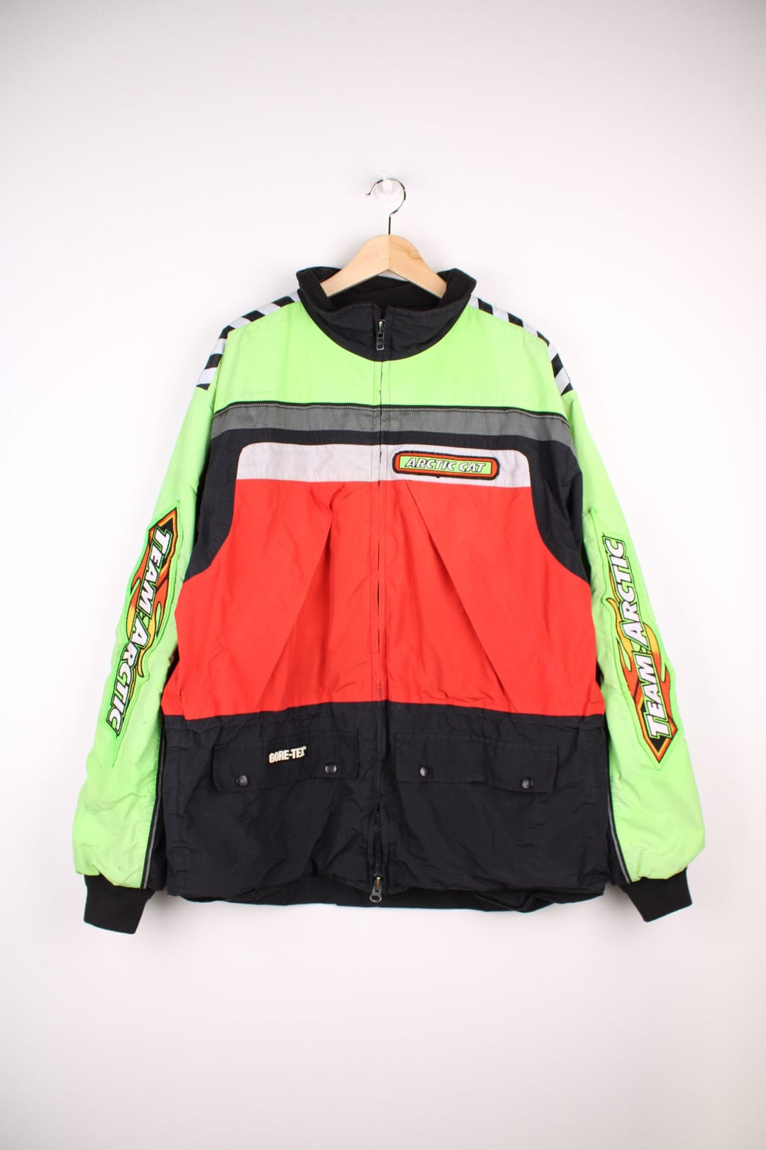  Vintage Arctic Cat racing jacket in a neon green and red colourway. The jacket is from the Arctic Cat, a snowmobile manufacture who also have teams in the Snowmobile Racing leagues. The jacket is gore-tex, has a fleece collar and multiple embroidered patches on the sleeves, front and back.  