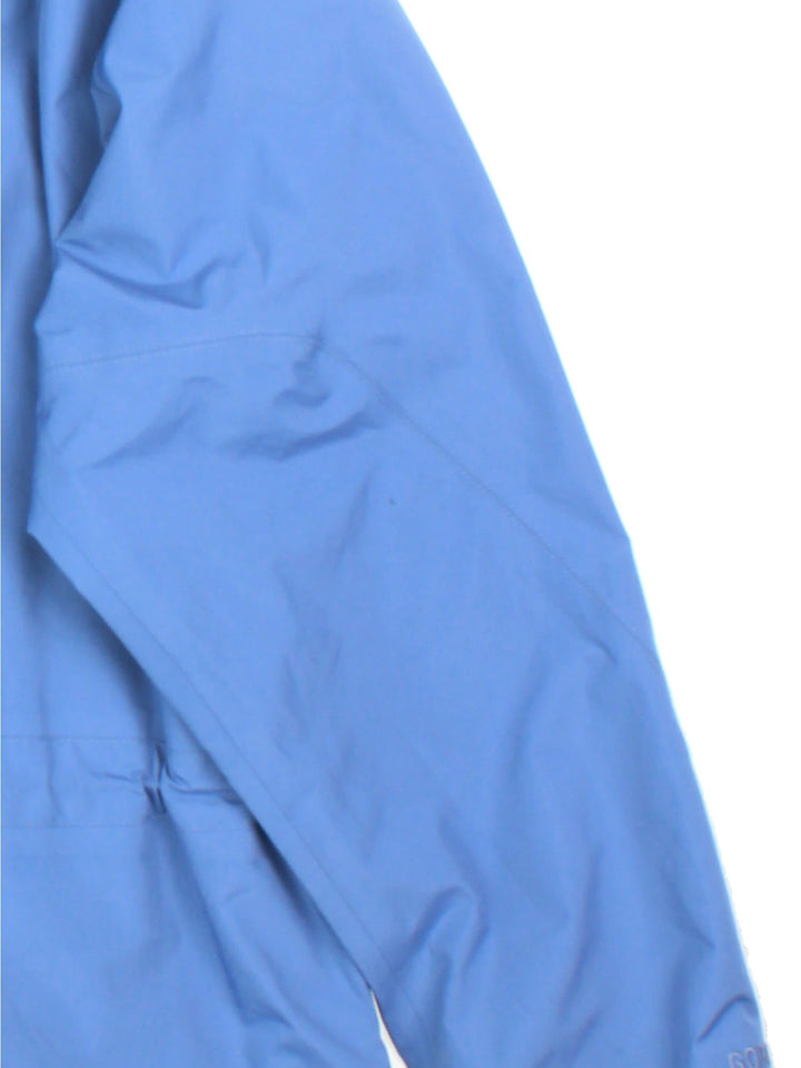 Berghaus Gore-Tex Jacket in a blue colourway. Zips up and has side pockets, mesh lining, hooded, and has the logo embroidered on the front.