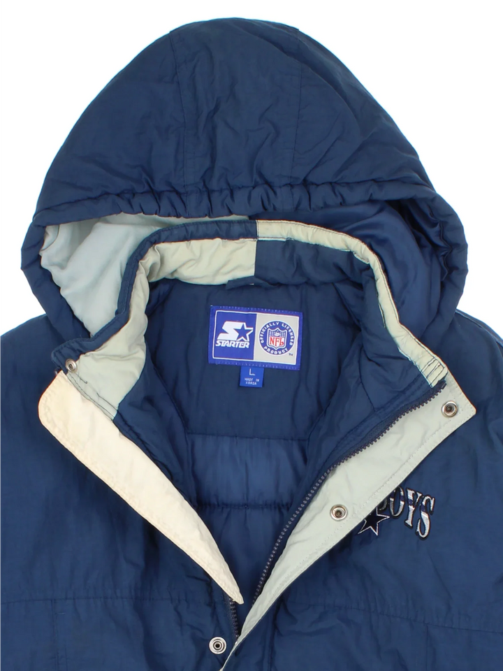 Vintage Dallas Cowboys NFL Starter Jacket in a blue colourway. Zips and buttons up, has side pockets, insulated lining, hooded, and has the team logo embroidered on the front and back.