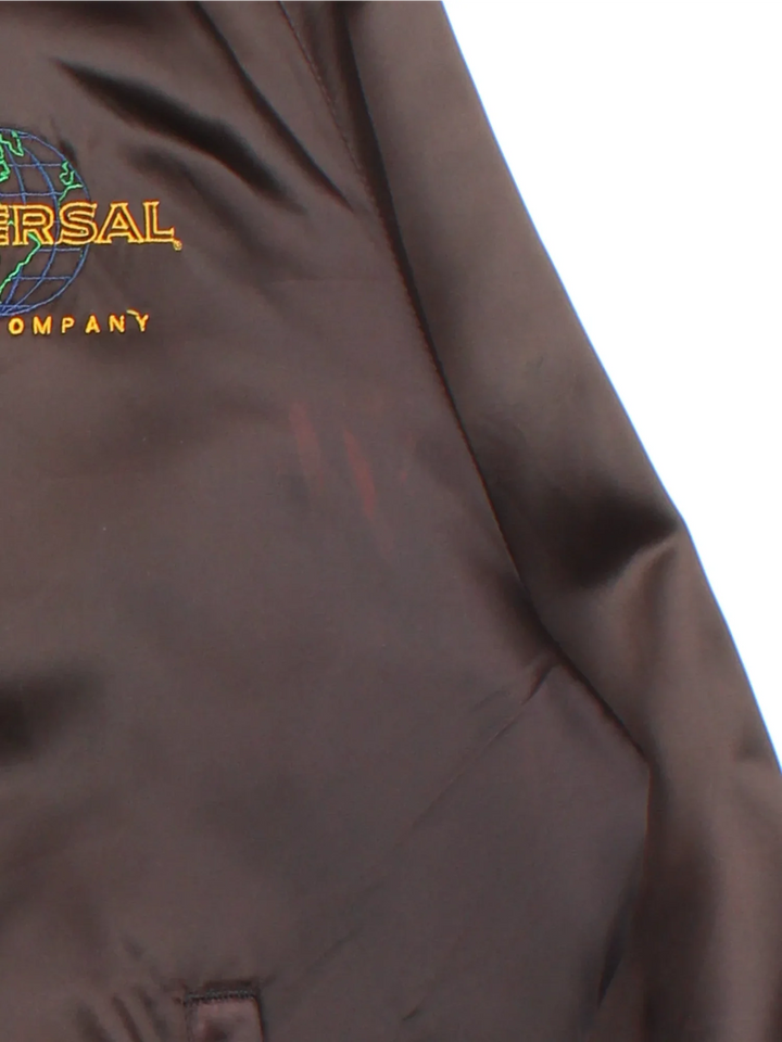 Vintage Universal Studios Varsity Jacket in a brown colourway. Zips up and has side pockets, and the logo embroidered on the front and back.